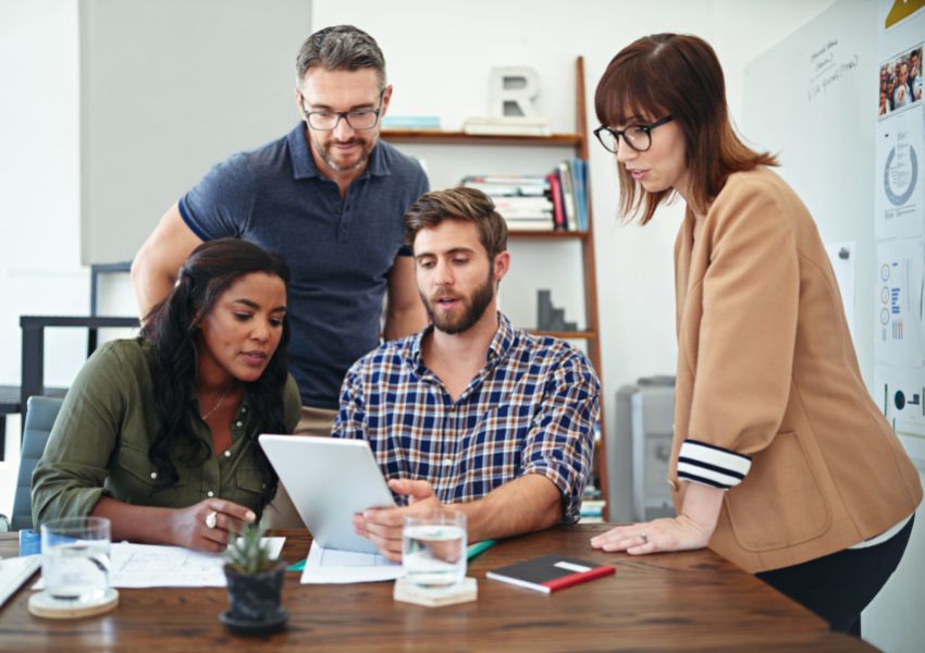 team-of-people-gathered-around-tablet